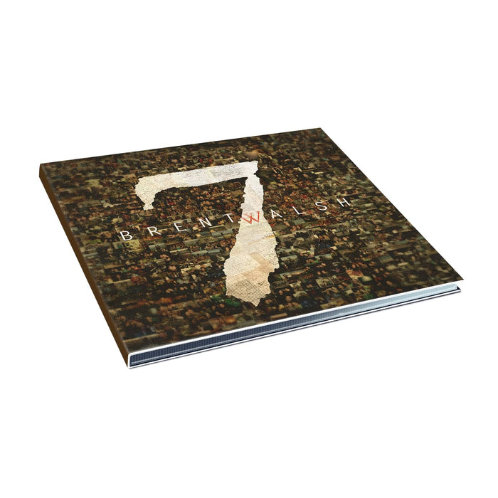 A music album by Brent Walsh featuring a bold white number 7 on a mosaic cover of small images. The slightly open CD case rests on a white background, inviting a peek at the intriguing track listing inside.