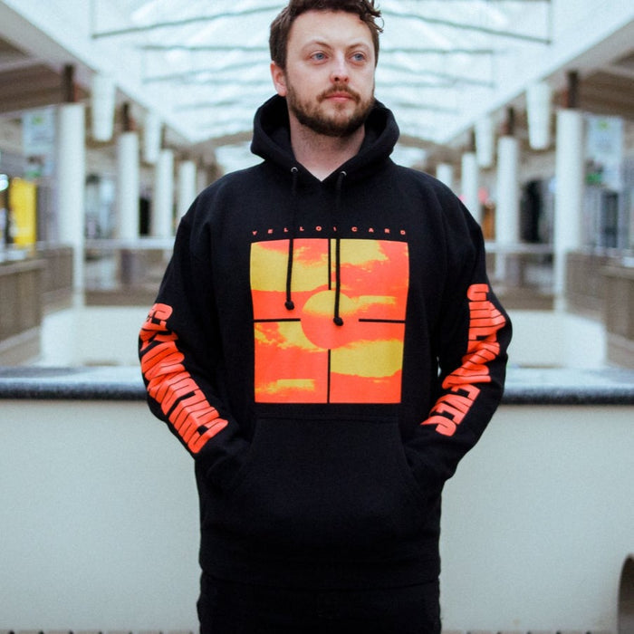 A photo of a man wearing the sweatshirt inside of a mall.