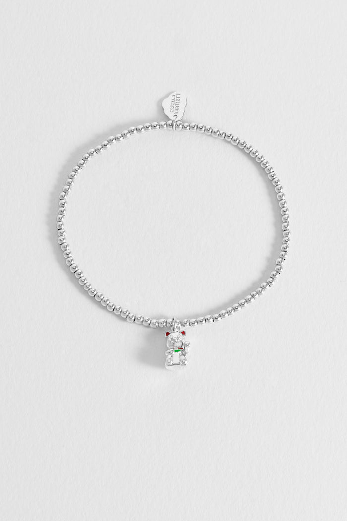 Silver bracelet with a small pendant on a light gray background