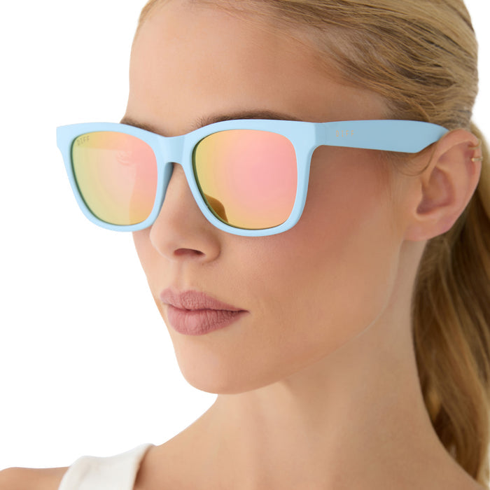 on model - female wearing diff sport featuring the storm square sunglasses with a matte baby blue frame and sherbert rainbow mirror polarized lenses side view