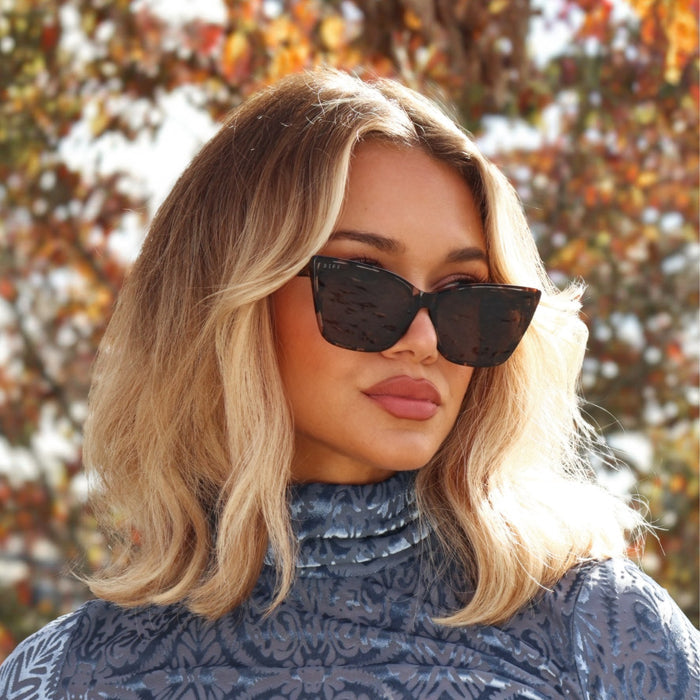 lifestyle - minimally her wearing cat eye tort sunglasses with fall fashion and fall leaves