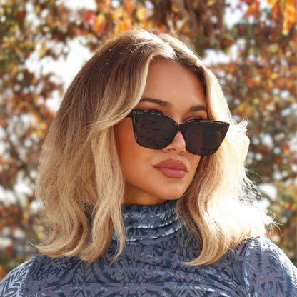lifestyle - minimally her wearing cat eye tort sunglasses with fall fashion and fall leaves