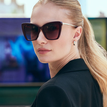 lifestyle - female wearing diff eyewear featuring the becky ii cat eye sunglasses with a dark cherry lacquer frame and dark cherry gradient polarized lenses angled view