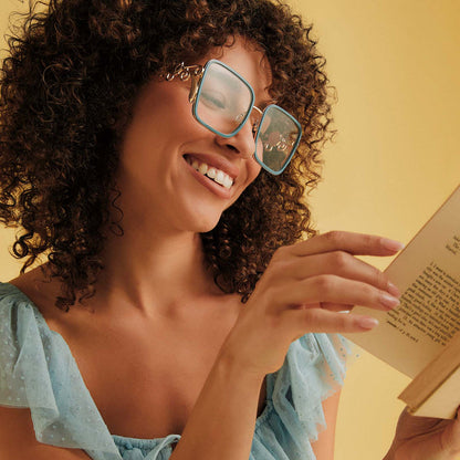 on model - female wearing disney princess x diff eyewear featuring the belle 2.0 prescription glasses with a gold and blue frame angled view