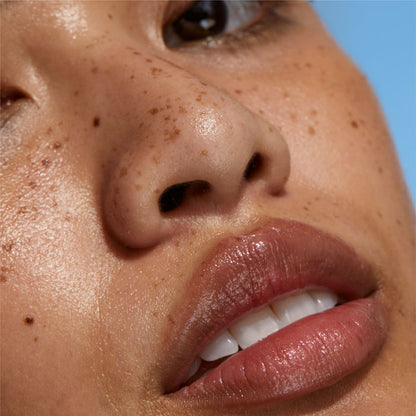 Close-up of a person's nose and mouth with a clear blue sky background