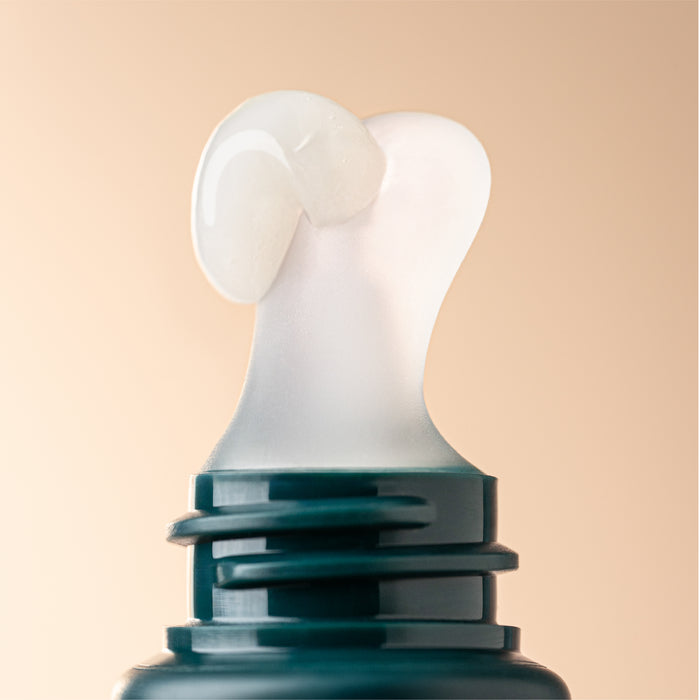 Close-up of a lip treatment applicator with product on a beige background