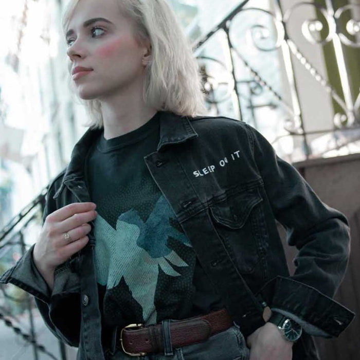 Photo of a woman wearing the jacket in front of a building landing area