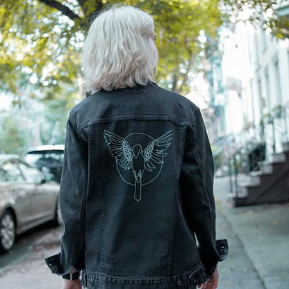 Photo of the same woman showing off the back of the jacket on a city sidewalk.