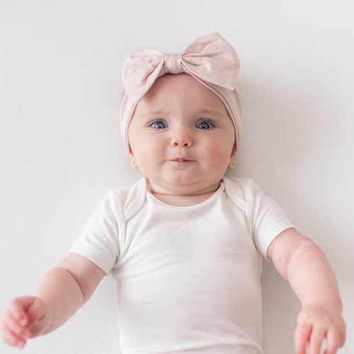 Baby wearing Bow Headband in Blush and Cloud Bodysuit