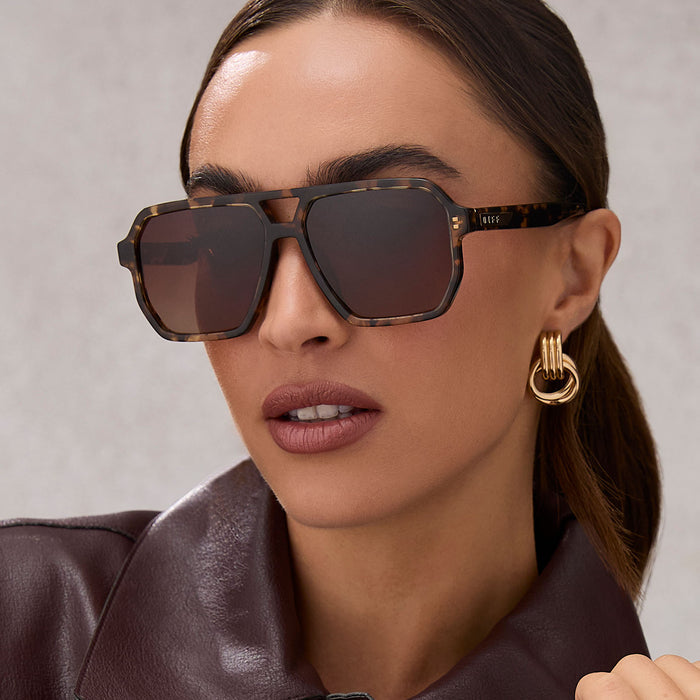 on model - female wearing diff eyewear featuring the cameron navigator sunglasses with a espresso tortoise frame and brown gradient polarized lenses angled view