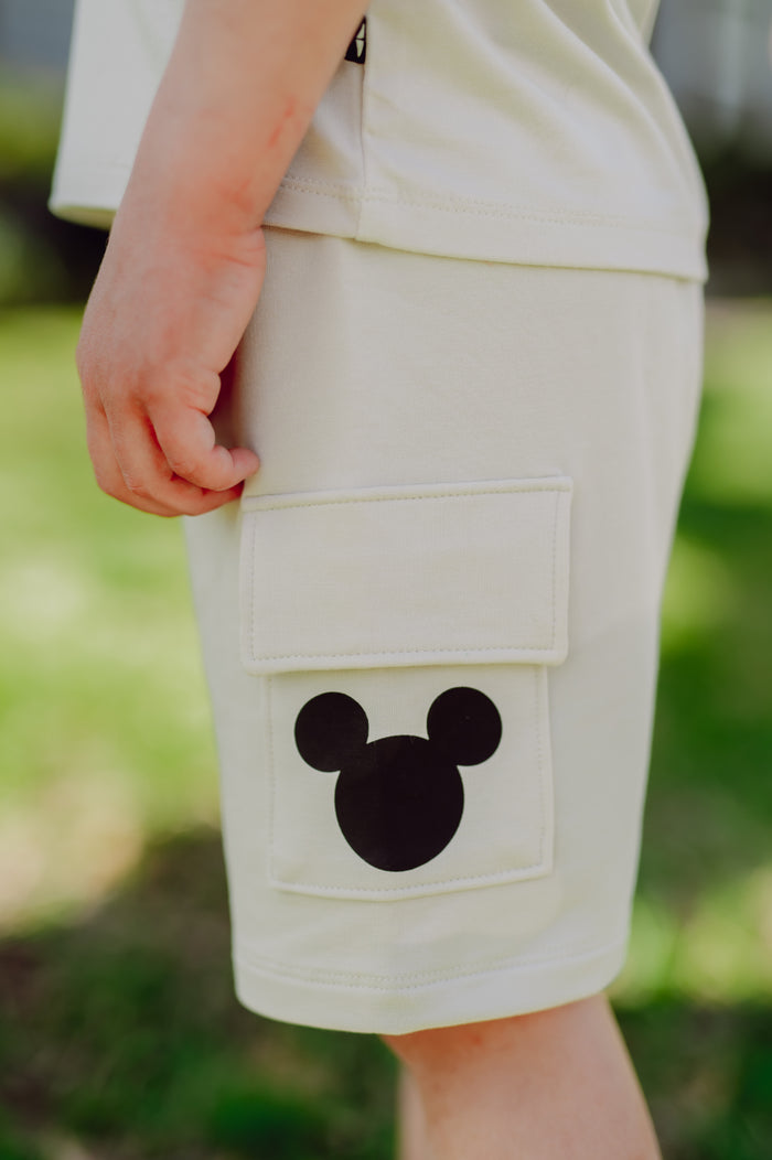 Child wearing cargo shorts with a black mickey head on the pocket