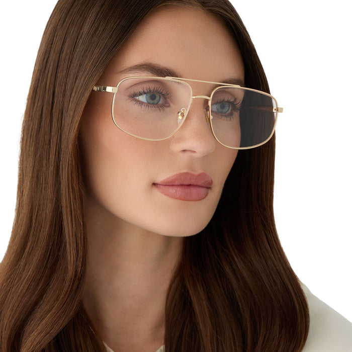 on model - female wearing diff eyewear featuring the charley navigator glasses with a gold metal frame angled view
