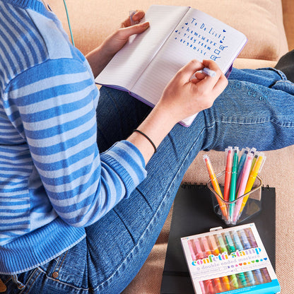 Girl creating to-do list with set of OOLY Confetti Stamp Double-Ended Markers close up