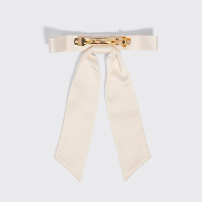An off-white satin bow tie with a gold-tone metal clasp, displayed flat against a light gray background.
