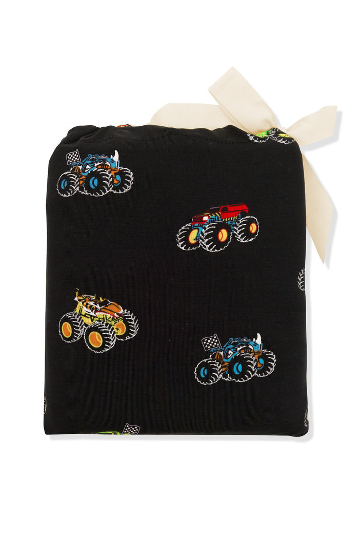 Crib Sheet packed in a colorful Monster Truck print bag on white background