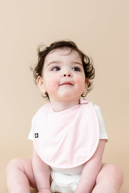 Baby wearing Cushy Bib in Sakura Pink