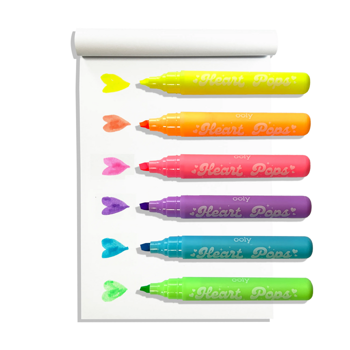 White sketchbook with row of uncapped OOLY Heart Pops Neon Highlighters with heart swatches on white background