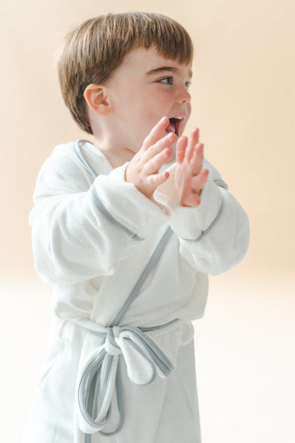 Young boy clapping wearing the Hooded Bath Robe in Cloud with Storm Trim