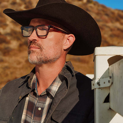 lifestyle - male with cowboy hat wearing yellowstone x diff eyewear featuring the john dutton rectangle prescription glasses with a sequoia tortoise frame angled view
