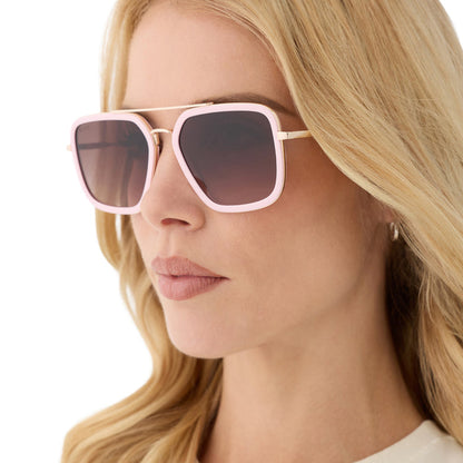 on model - female wearing diff eyewear featuring the jordan navigator sunglasses with a powder pink with gold frame and brown gradient lenses angled view