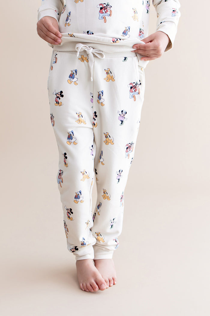 Cream colored jogger pant with mickey and friend character pattern with drawstring waist