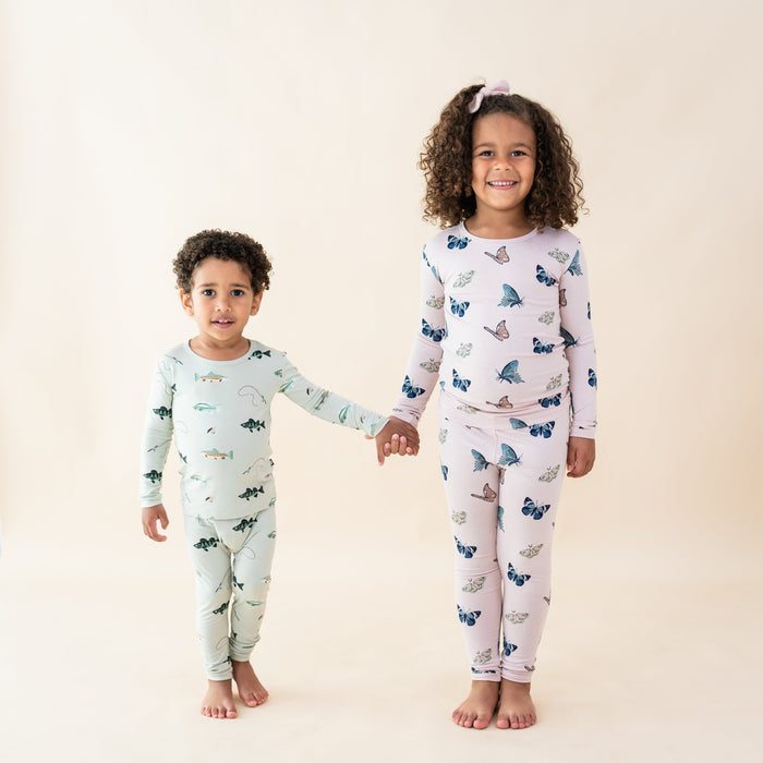 Kids wearing long sleeve pajama sets in fish and butterfly prints