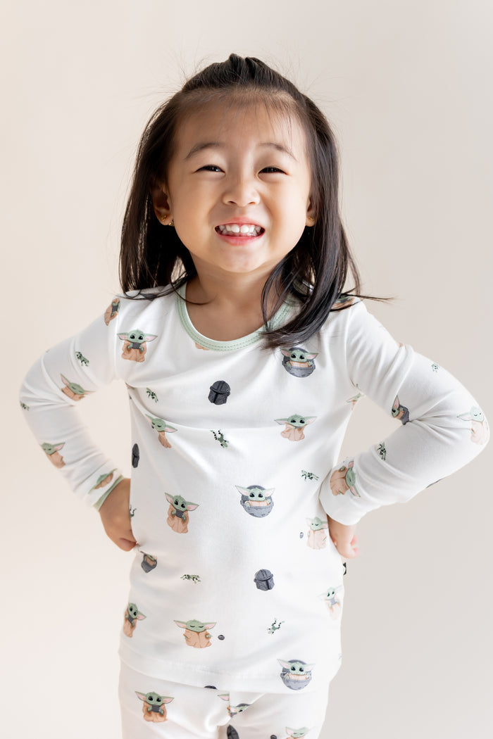 Girl posing in Long Sleeve Pajamas in Grogu™ print on a cream background