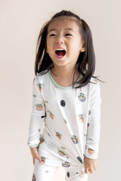 Girl wearing Long Sleeve Pajamas in Grogu™ print on a cream background