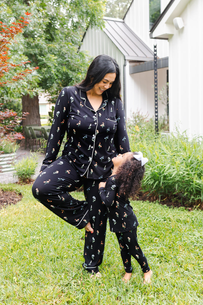 Girl and model smiling outdoors in a garden wearing Long sleeve pajama sets in Midnight Wildflower print