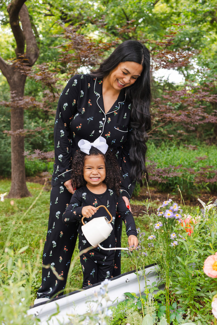 Girl and model standing outdoors watering plants wearing Long sleeve pajama sets in Midnight Wildflower print