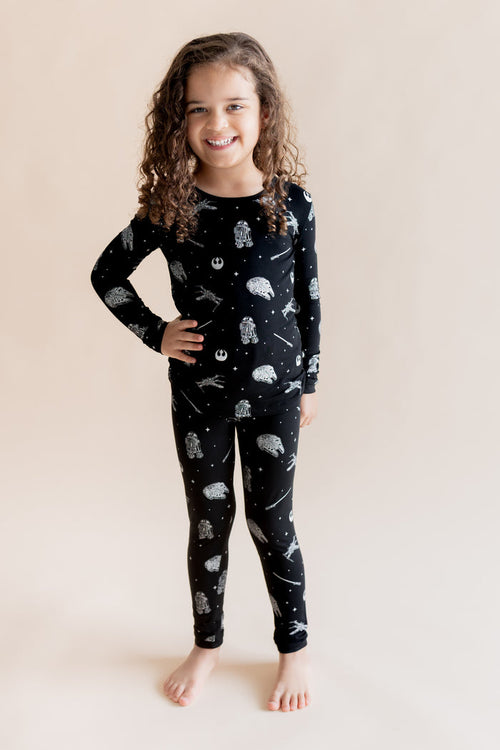 Girl wearing Long Sleeve Pajamas in STAR WARS™ print on a cream background