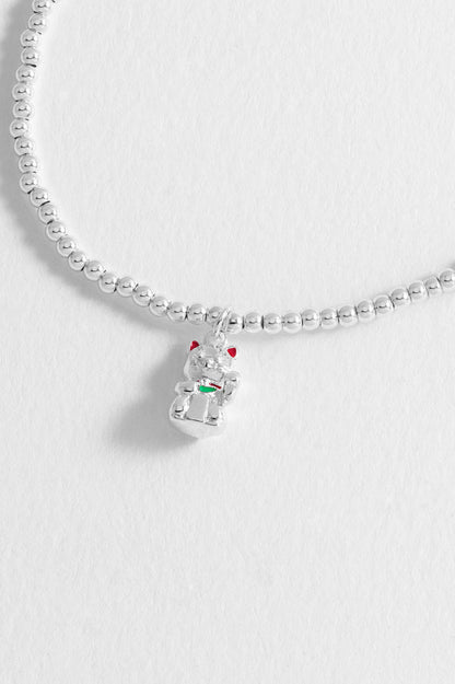 Silver beaded necklace with a snowman charm on a light gray background
