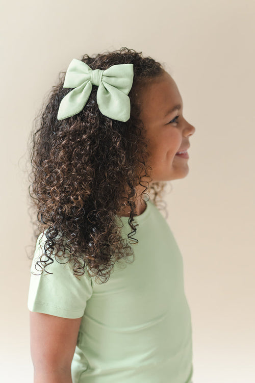 Medium Alligator Clip Bow in Basil shown in a young girls hair