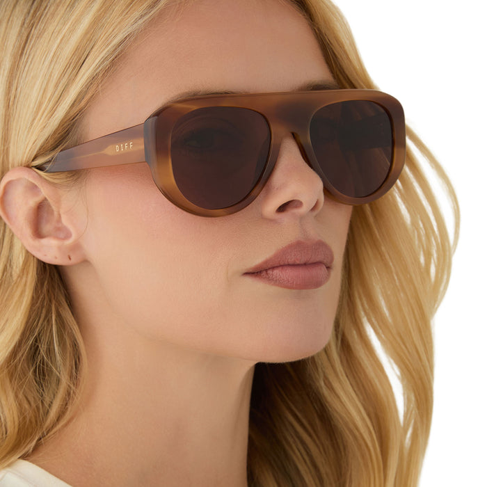 on model - female wearing diff eyewear featuring the morgan shield sunglasses with a tawny tortoise frame and brown lenses angled view