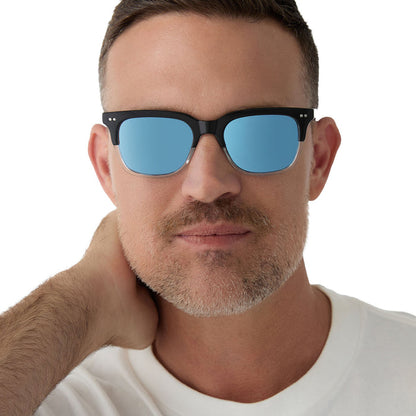 on model - male wearing diff eyewear x fantastic four featuring the mr. fantastic square sunglasses with a black to clear frame and quantum blue mirror polarized lenses front view