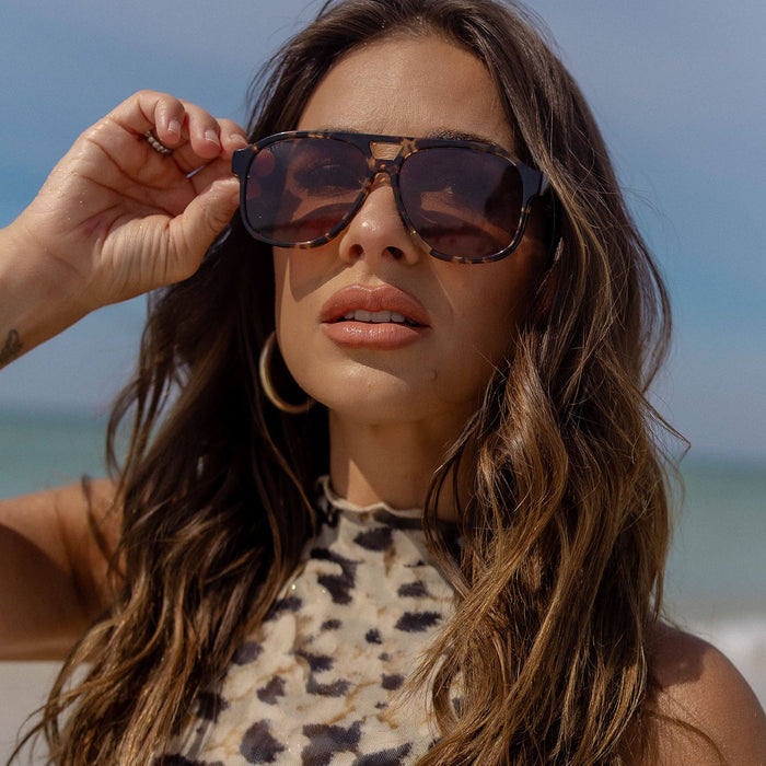 lifestyle - jessie james decker x diff eyewear featuring the nash navigator sunglasses with a espresso tortoise frame and brown lenses front view