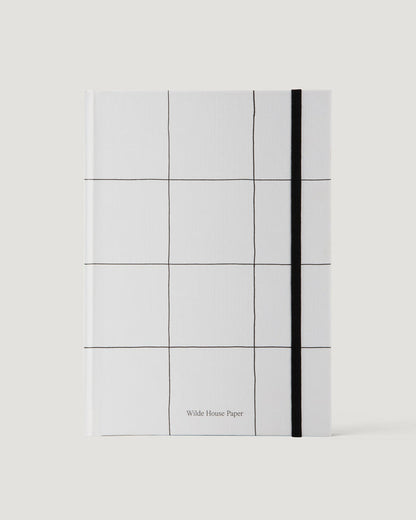 White notebook with grid pattern and black line on a white background