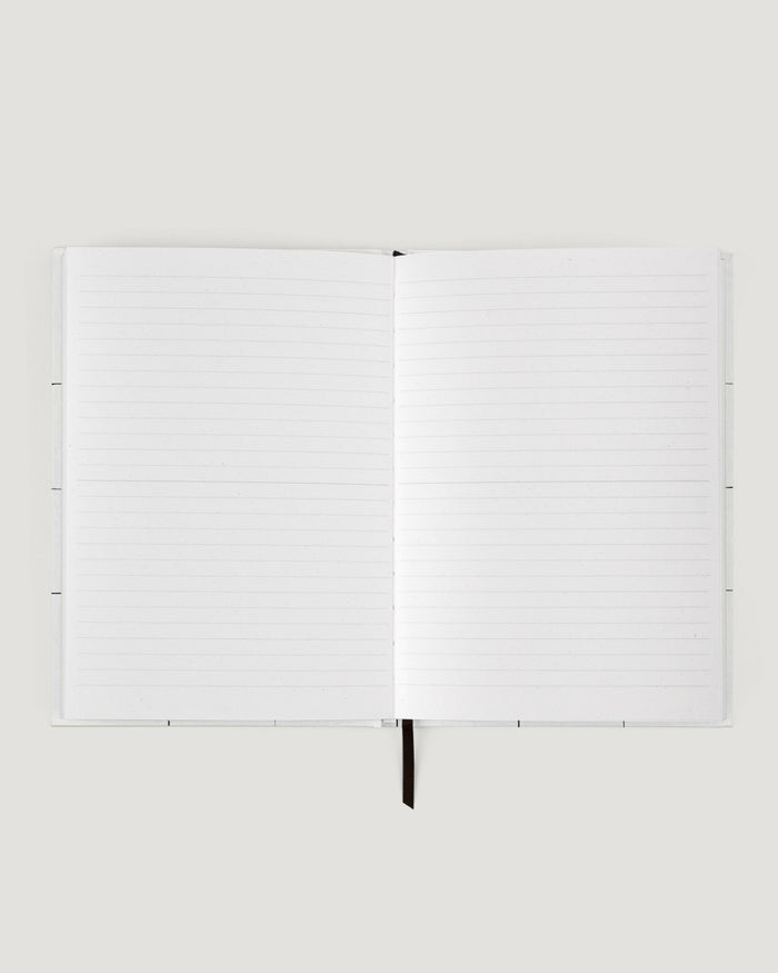 White notebook with a pen on a white background