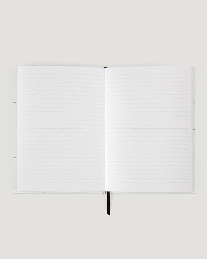 White notebook with a pen on a white background
