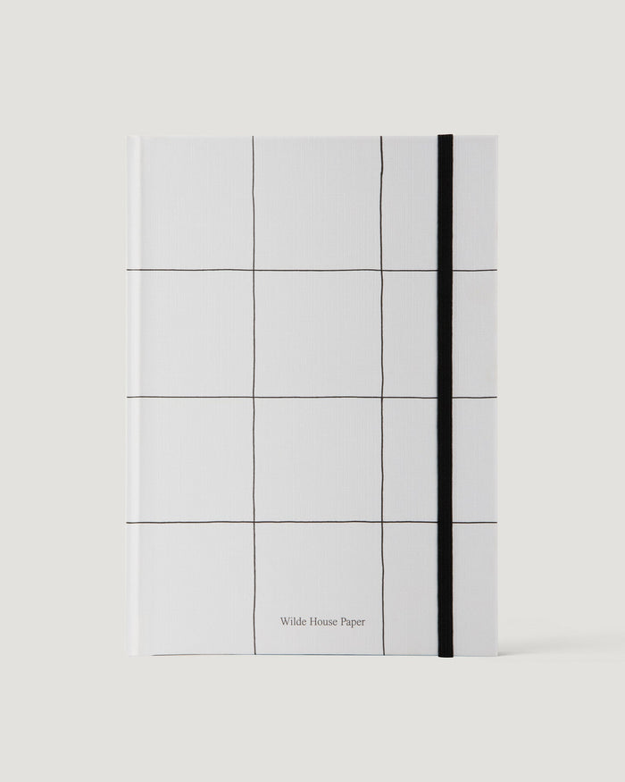 White notebook with grid pattern and black line on a white background