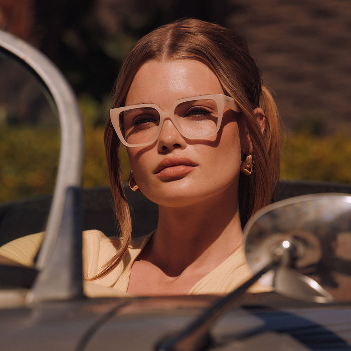 lifestyle - female driving wearing diff eyewear featuring the olive square prescription glasses with a milky blush frame