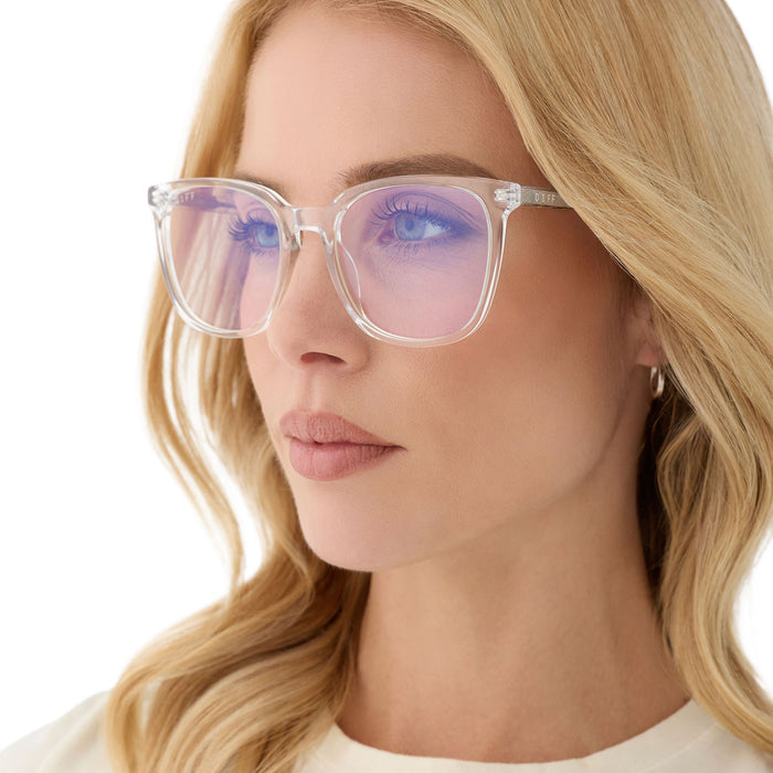 on model - blonde female wearing diff eyewear featuring the parker square blue light technology glasses with a clear frame angled view