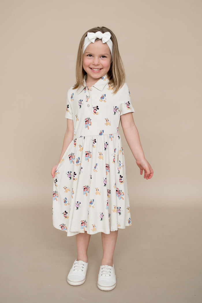 Young girl wearing a mickey character dress on a beige background