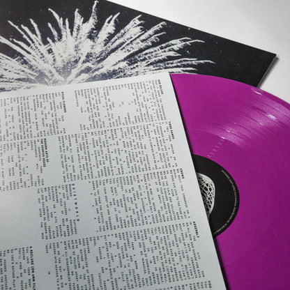 A vibrant purple Gatherers vinyl from the Quiet World limited pressing LP is partially pulled from a black & white abstract album cover, with a white lyric sheet featuring black text laid on top.