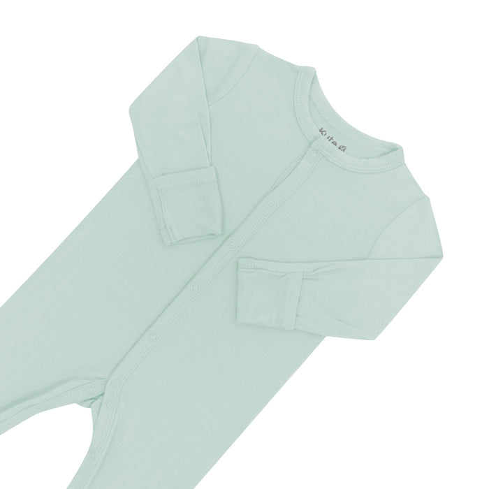 Close up of top portion of Kyte Baby Romper in Sage with arms folded in