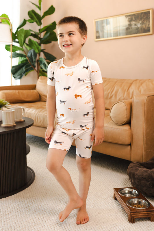 Boy wearing Beige Short Sleeve Pajamas in Dachshund print in a living room