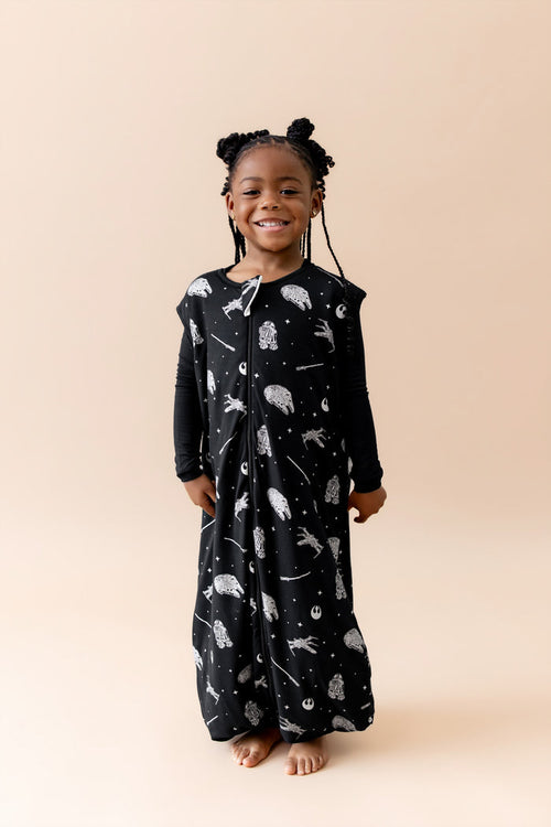 Smiling girl wearing the Sleep Bag Walker in STAR WARS™ 1.0 with long sleeve black pajamas on underneath
