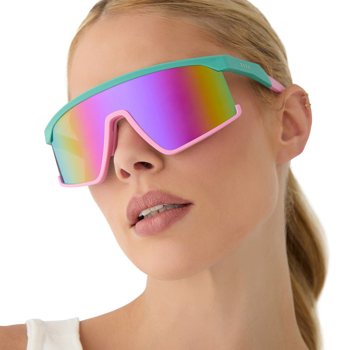 on model - female wearing diff sport featuring the spike shield sunglasses with a turquoise & hot pink frame and pink rush mirror polarized lenses front view