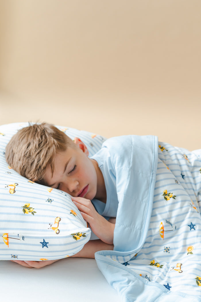 Young boy laying in a bed wearing the Standard Pillowcase in Amalfi Coast