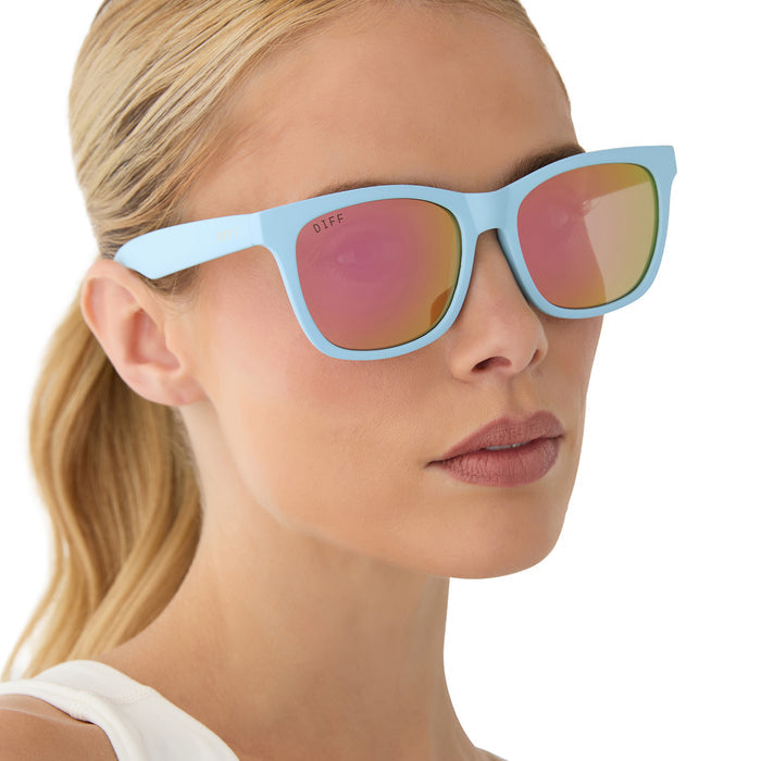 on model - female wearing diff sport featuring the storm square sunglasses with a matte baby blue frame and sherbert rainbow mirror polarized lenses angled view